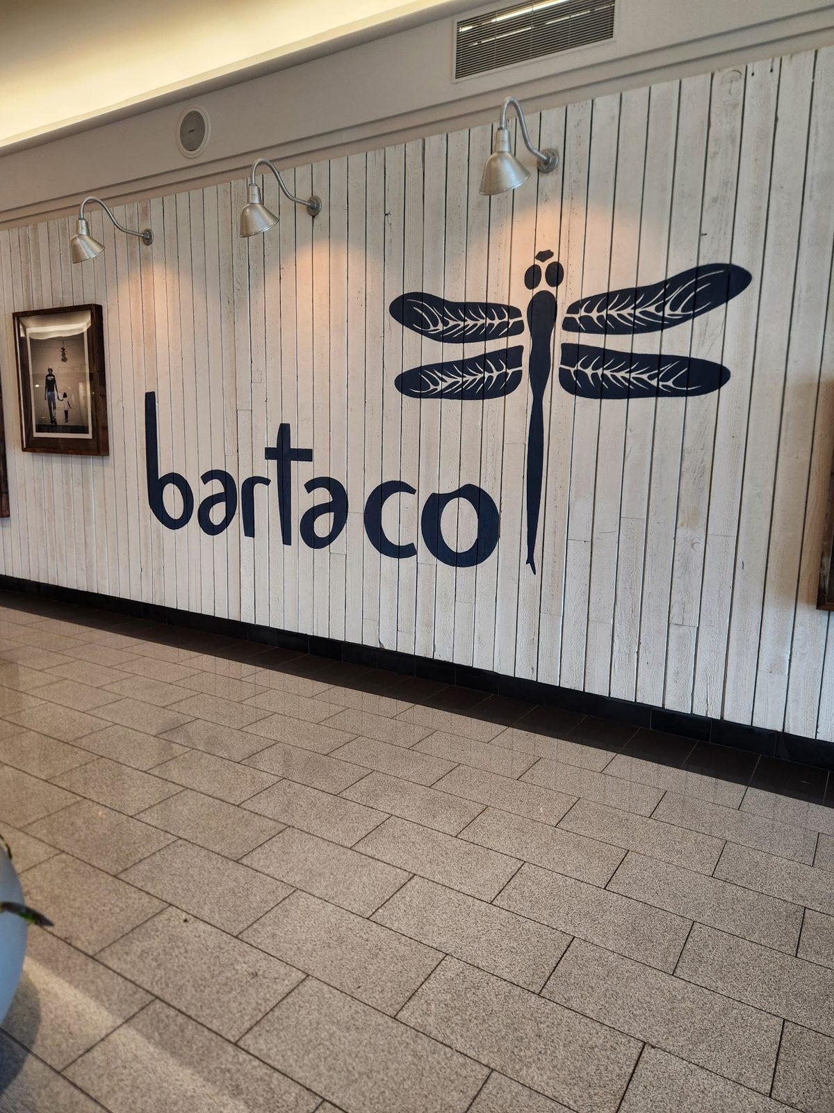 Shiplap wall at a bartaco restaurant painted white above a dark base